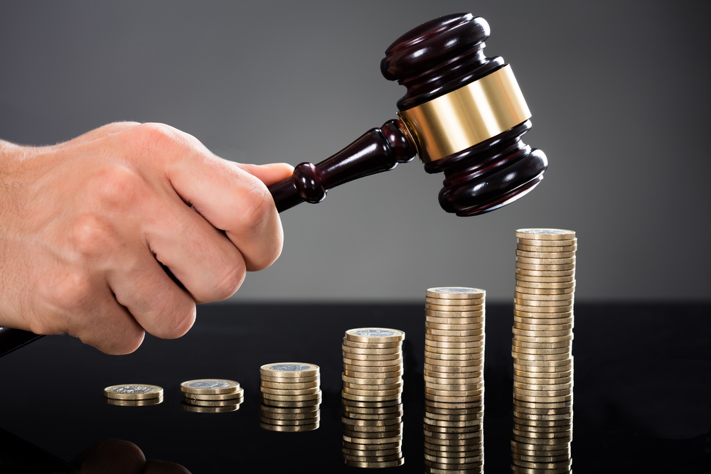 Lawyer holding a gavel over some money at a New York City, NY Law Firm