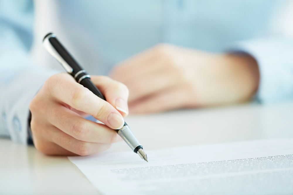 Person signing a contract at an Upper East Side, NY Law Firm